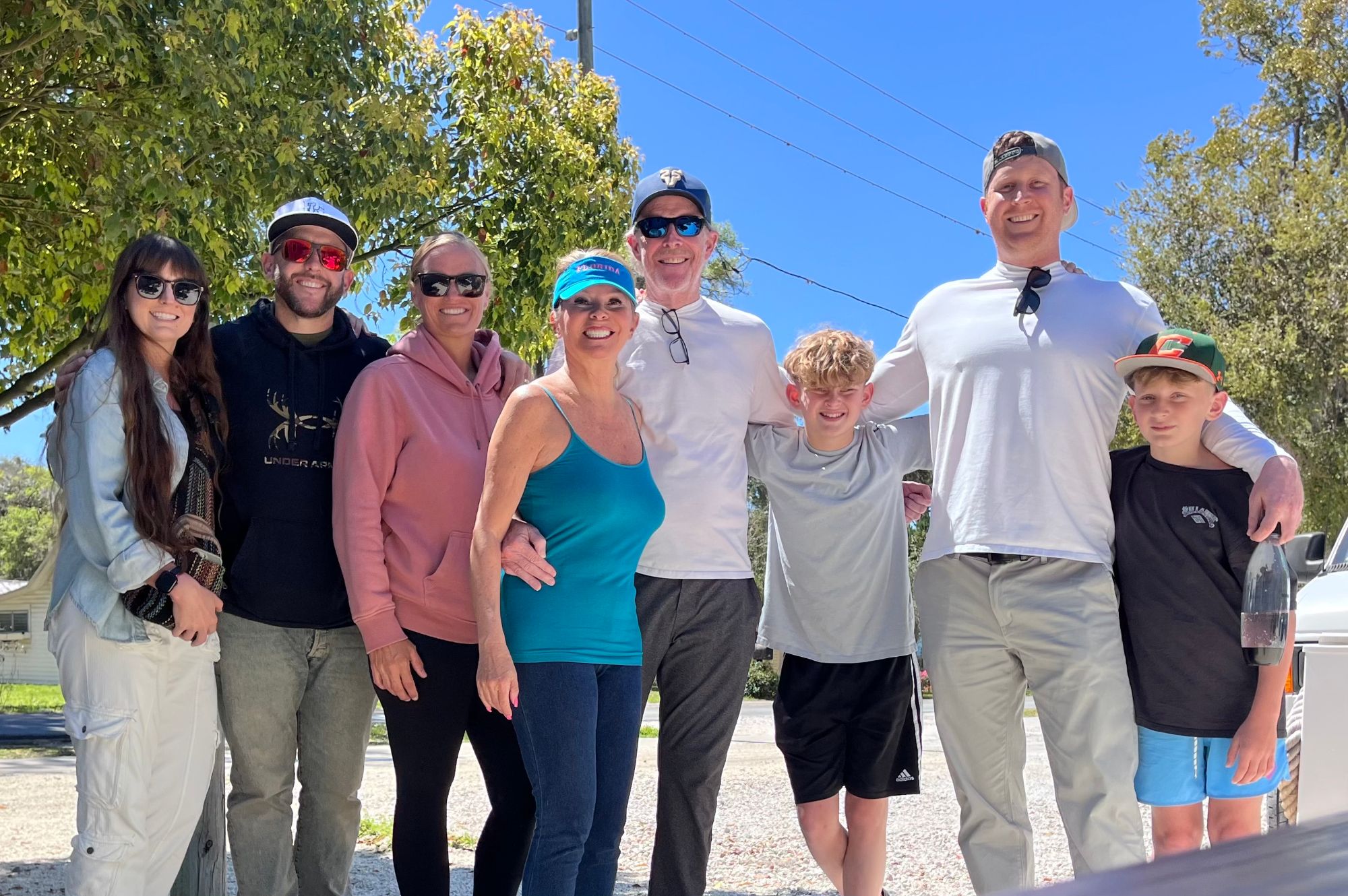 Amber with her husband, sons, and extended family standing together outside on a sunny day